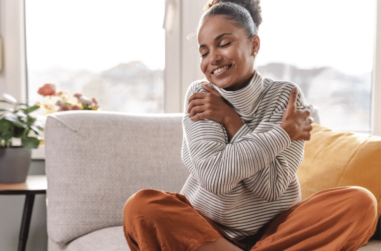 Woman hugging herself as a form of self-care to support her wellness